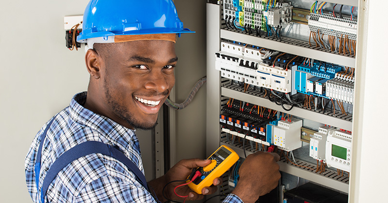 Smiling Electrician Working on Wiring