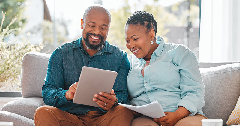 Male and Female Smiling and Looking Over an Invoice