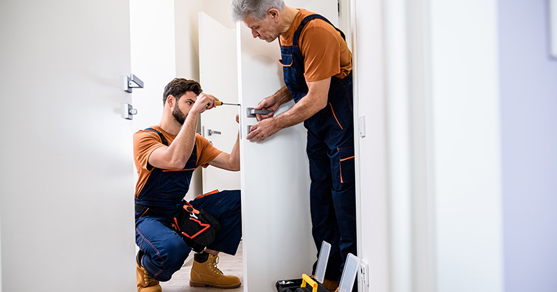 Two Locksmiths Working Together on the Same Door