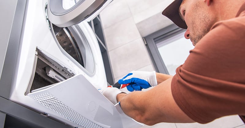 Repair technician working on washer