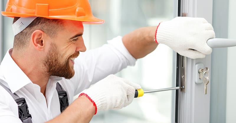 Happy locksmith working on door