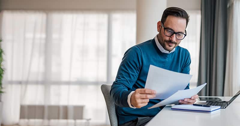 Man looking at papers and thinking