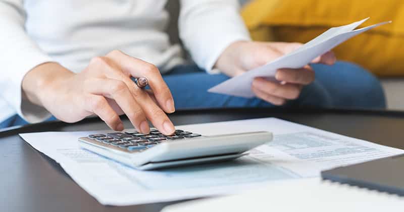 Woman hands using calculator to budget