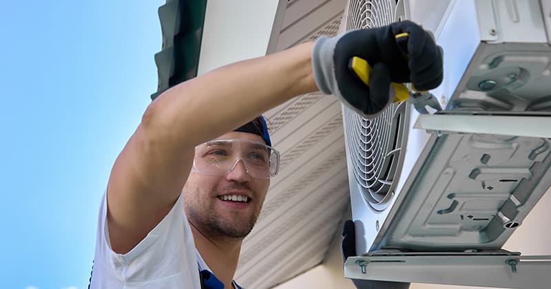 HVAC professional smiling and working