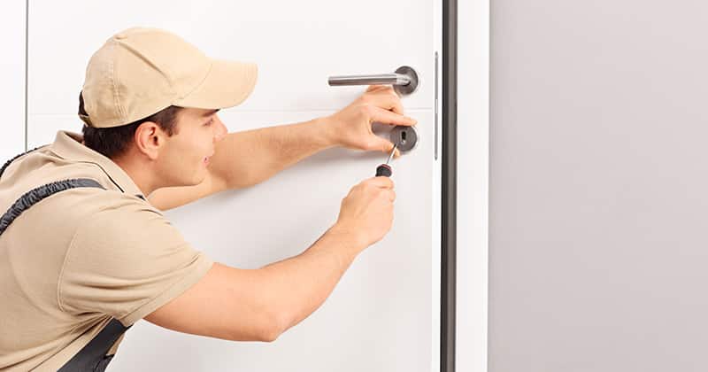 Locksmith installing a lock on a door