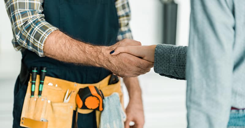 Plumber and customer shaking hands