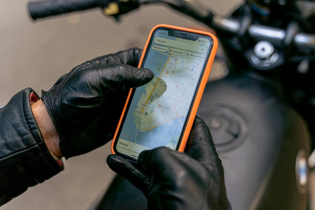 Technician using a smartphone with a map to track job locations, ensuring efficient routing and updates.